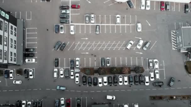 Вид зверху на автостоянку з припаркованими машинами поблизу ділового центру в мегаполісі, проміжок часу відео. Автомобілі стоять біля торгового центру — стокове відео