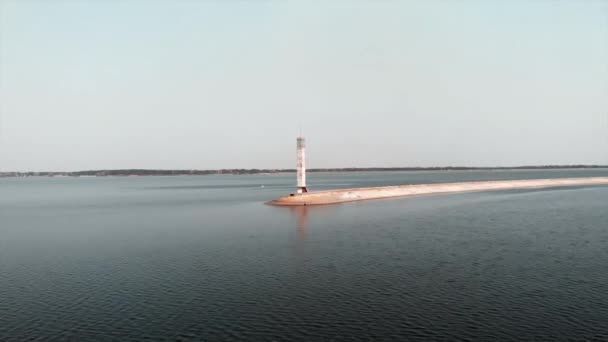 Беспилотник летит рядом с гидроэлектростанцией с маяком. Вид с воздуха на спокойное озеро с голубой водой — стоковое видео