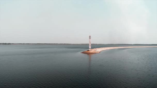 Маяк гидроэлектростанции. Воздушный беспилотный вид на озеро с маяком — стоковое видео
