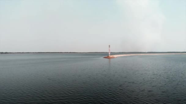 Вид с воздуха на маяк, окруженный морской водой. Водная электростанция в Киеве, Украина с высоты птичьего полета. Беспилотник, летящий над морской водой возле маяка — стоковое видео