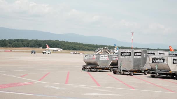 Γενεύη / Ελβετία -Ιούλιος, 22 2019 - Ελβετικές αεροπορικές εταιρείες που προσγειώνονται στο αεροδρόμιο της Γενεύης με ειδικά ρυμουλκούμενα οχημάτων Unilode στην μπροστινή πλευρά. Αεροπλάνα Easyjet και Flyuia σταθμευμένα στο διάδρομο — Αρχείο Βίντεο