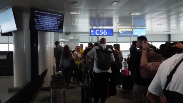 Geneve / Schweiz -juli, 22 2019 - passagerare med handbagage står nära gate C52 och väntar på ombordstigning på flygplan i Genève flygplats, bakre vy — Stockvideo