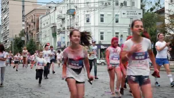 Kiev / Ukraina - 2 juni 2019 - Charmiga små flickor och pojkar är insmorda fluorescerande ljusa holi färger som körs på färgfestival på Color Run — Stockvideo