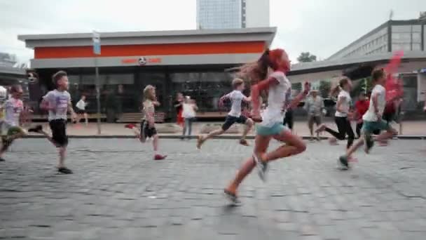 Kyiv/Ukraine - June 2, 2019 - Young boys and girls running along city center with colorful holi paints in hands at Color Run — Stock Video