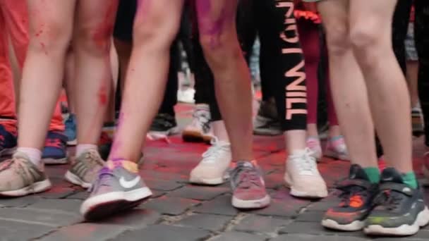 Kiev / Ucrania - 2 de junio de 2019 - Vista lateral de las piernas de los niños pequeños en zapatillas preparándose para la carrera en la línea de partida en Color Run — Vídeo de stock