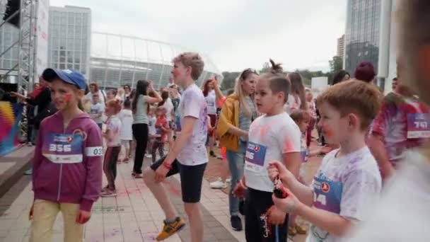 Kijów / Ukraina - 2 czerwca 2019 - Szczęśliwe dzieci i dorośli bawią się i tańczą w pobliżu sceny na festiwalu farb w Color Run — Wideo stockowe