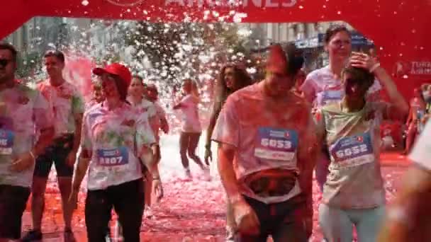 Kijów / Ukraina - 2 czerwca 2019 - Czarująca szczęśliwa młodzież poplamiona kolorowymi farbami zakończony wyścig Color Run w centrum — Wideo stockowe