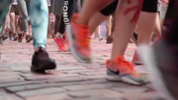 Kijev / Ukrajna - Június 2, 2019 - Nő és férfi láb tornacipőben kocogás útburkoló kövek a város központjában Color Run — Stock videók
