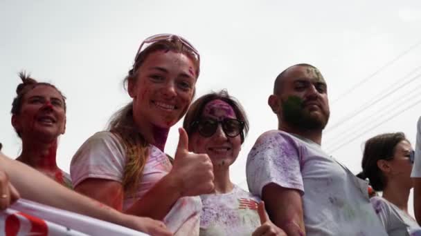 Kiev / Ukraine - Le 2 juin 2019 - Visages de deux heureuses femmes caucasiennes souriantes teintées de peintures fluorescentes colorées holi à Color Run — Video