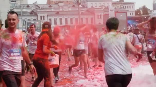 Kiev / Ucrânia - 2 de junho de 2019 - Jovem mulher atraente espalhando tintas holi fluorescentes coloridas em pessoas em execução no festival de tintas em Color Run — Vídeo de Stock