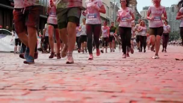 Kyiv/Ukraine - June 2, 2019 - Happy charming smiling women and men in white clothes stained in colorful fluorescent indian holi paints running at paints festival at Color Run — Stock Video