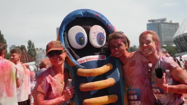 Kiev / Ukraine - Le 2 juin 2019 - De jeunes femmes heureuses ont enduit de peintures colorées holi en prenant des photos et en souriant à l'appareil photo lors du festival de peintures à Color Run — Video