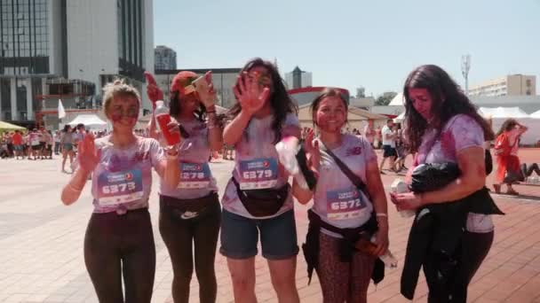 Kiev / Ukraine - 2 juin 2019 - Joyeuses jeunes femmes souriantes teintées de peintures fluorescentes colorées indiennes holi dansant et s'amusant au festival de peintures à Color Run — Video