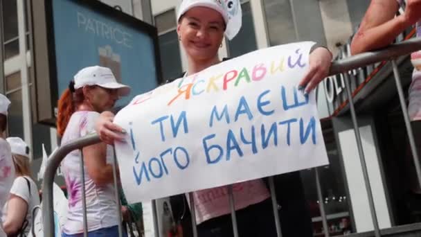 Kyiv/Ukraine - June 2, 2019 - Attractive young woman standing with poster "the world is bright and you have to see it"  at paints festival at Color Run — Stock Video