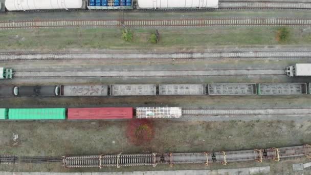 Şehrin sanayi bölgesindeki kargo yük trenlerinin ve tren raylarının insansız hava aracı görüntüsü. Demiryolunda malları olan vagonlar.. — Stok video