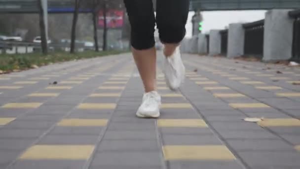 Όμορφη λεπτή τακτοποίηση πόδια γυναίκα έντονη τρέχει σε περιπάτους στο βιομηχανικό τμήμα της πόλης. Αθλητής με άσπρα υποδήματα που κάνει προπόνηση και γρήγορο τρέξιμο στο κέντρο — Αρχείο Βίντεο