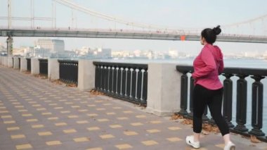 Genç ve tatlı bir dişi sabah tek başına şehir nehrinde koşuyor. Maraton yarışı için antrenman