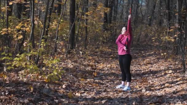 Mujer gorda motivada con bastones nórdicos que estiran los brazos y el cuerpo antes de la actividad deportiva al aire libre — Vídeos de Stock