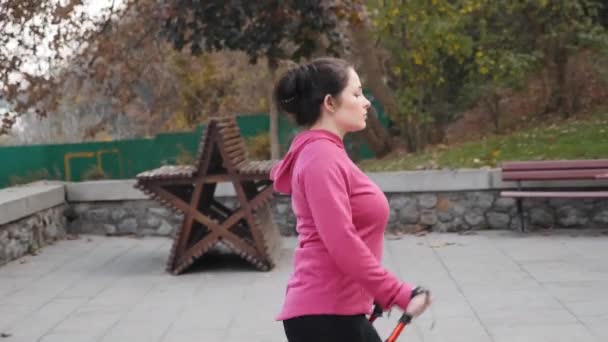 Σκανδιναβικό περπάτημα έννοια. Νεαρή εστιασμένη παχουλή γυναίκα ανεβαίνει τις σκάλες ως μέρος της κάθε μέρα προπόνηση απώλειας βάρους της — Αρχείο Βίντεο