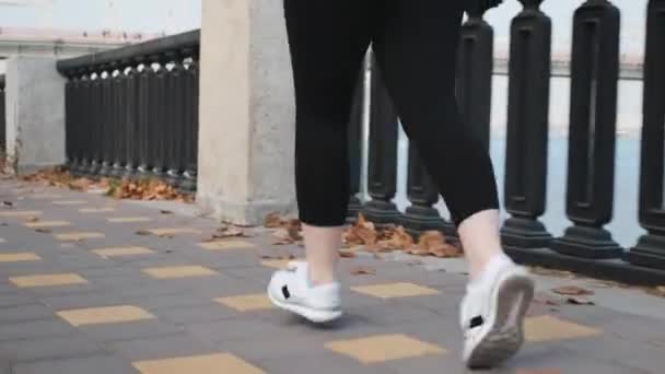 Précédent follow view of chubby female doing running workout in industrial city park alone river. Concept de fitness — Video