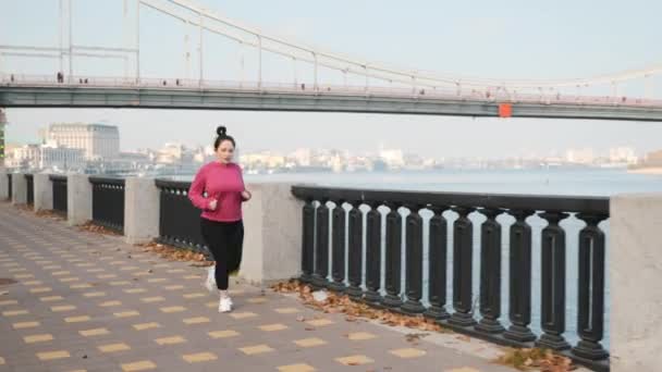 Koşu yaparak ve işe gitmeden önce dışarıda kardiyo yaparak kilo vermeye çalışan motive bir kadın. Çalışan konsept — Stok video