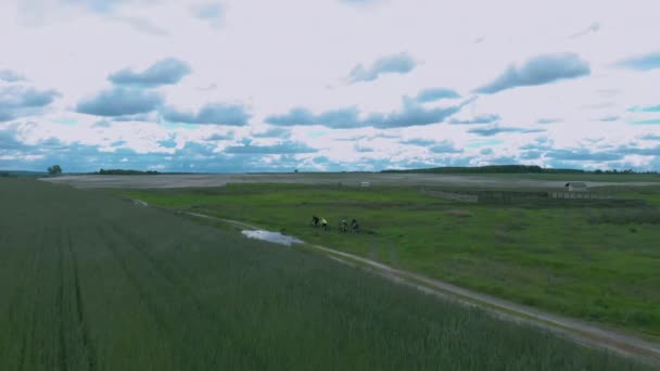Groupe de cyclistes chevauchant au milieu du terrain, vue aérienne sur drone. Hommes et femmes font du VTT hors route. Personnes actives voyageant à vélo, à vélo sur des vélos dans les champs 