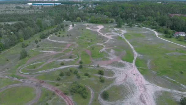 Motocross pista motociclistica con circuiti sterrati chiusi con ostacoli ripidi circondati dalla foresta. Pista professionale vuota del motociclo, vista aerea del drone — Video Stock