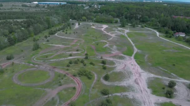 Drone vola sopra vuoto pista professionale motocross moto nel mezzo della foresta contro cielo nuvoloso blu. Veduta aerea della pista di motocross — Video Stock