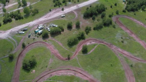 Vista aérea da pista de corrida de moto no meio da floresta. Trilha de motocross com motociclista de corrida em circuito de sujeira artificial fechado com saltos íngremes e obstáculos. Motocross bike em pista de corrida — Vídeo de Stock