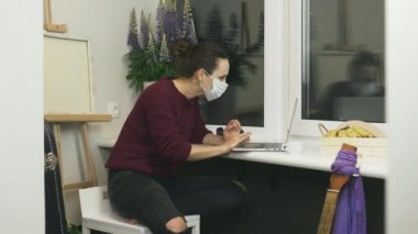 Koruyucu tıbbi maske takan heyecanlı genç kadın karantinanın sonuyla ilgili haberler aldı. Karantinanın sona ermesini kutlayan mutlu kadın gülümsemesi. İnternetten iyi haber izleyen kadın.