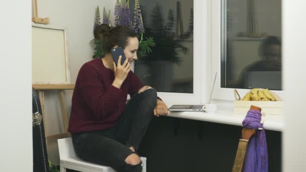 Szczęśliwa kobieta rozmawiająca przez telefon z przyjaciółmi, uśmiechnięta i śmiejąca się przebywająca w domu w przytulnym nowoczesnym mieszkaniu. Kobieta rozmawiająca przez telefon z partnerami biznesowymi, zawierająca umowę na odległość podczas samodzielnej izolacji — Wideo stockowe