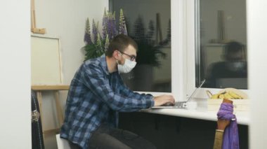 Koruyucu tıbbi maske takan heyecanlı genç adam karantina tecridinin sona erdiği haberini aldı. Karantinanın bitmesini kutlayan mutlu erkek. E- posta ile alınan iş tanıtımından heyecan duyan adam