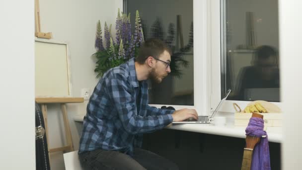 Jongeman ontving succesvol nieuws per e-mail over vacature promotie. Man blij en enthousiast met goede resultaten op de financiële markten zitten op balkon thuis. Man ontvangt een e-mail met positief nieuws — Stockvideo