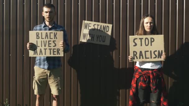 Folk med pappplakater som "Black Lives Matter" og "Stop Racism" i sine hender. En protest. Rettferdighet i USA. Politisk møte. Rallies mot politivold. Folk protesterer for like rettigheter – stockvideo