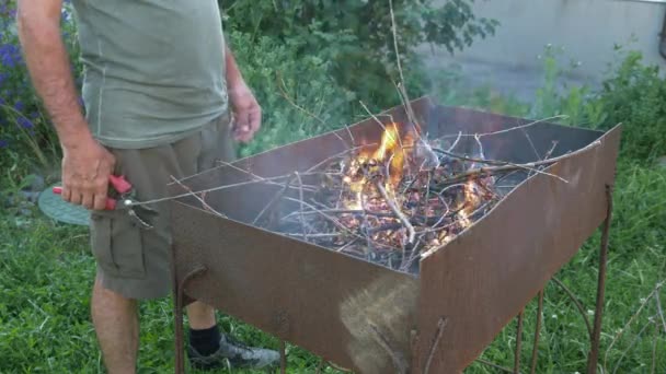 Płonące drzewa. Grill grill płomień grill Ogień. Człowiek rozpala ogień z drewna na grilla. Płonące paluszki drzew w grillu. Gotowanie żywności z ogniska — Wideo stockowe