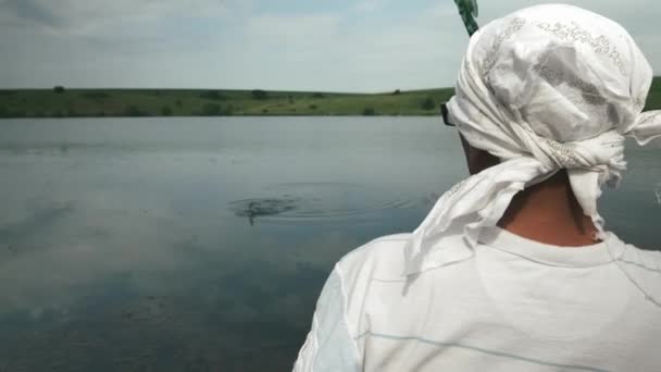 De mens ving vis met een hengel op het meer. Visser vissen in boot op de rivier. Visserij met behulp van hengels in het reservoir. Lifestyle en mensen concept — Stockvideo