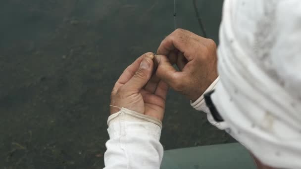 Чоловічі рибальські руки готують приманку на гачок. Річкова риболовля. Людина з приманкою для риболовлі на гачку для риболовлі на відкритому повітрі. Риболовля на озері. концепція хобі риболовлі — стокове відео