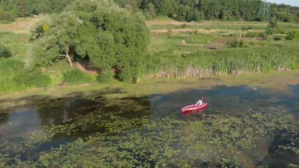 Frau mit Ruder in der Hand paddelt im Kajak auf dem Fluss. Touristinnen sind im Kanu auf dem Fluss unterwegs. Mädchen Reisenden ist die Erkundung der schönen Landschaft mit dem Boot im Sommerurlaub. Wassertourismus — Stockvideo