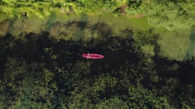 Gün batımında nehirde kayak yapmak. Sporcu kadın yazın kanoda süzülüyor. Kadın kanoyla nehir boyunca güzel manzaraları keşfediyor. Dişi turist gölde teknede yüzüyor. Su yolculuğu