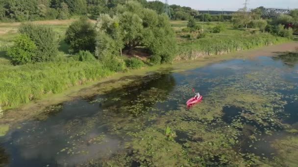 Drone view of woman floating in boat on river. Female is kayaking along beautiful landscape. Adventures holiday in summer. Sports girl explores river in canoe on holiday weekend. Water tourism — Stock Video
