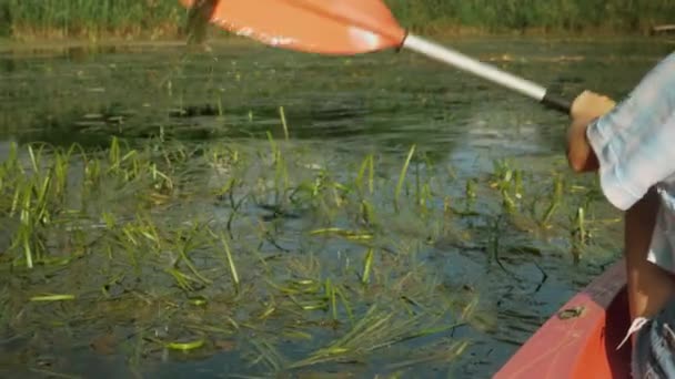 Remare a remi sul fiume. Il primo piano del remo di kayak sta remando in acqua. Una donna che fa kayak sul tranquillo fiume, dietro. La femmina sta remando sul lago. Attività avventurose. Turismo acquatico — Video Stock