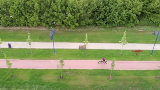 Jonge fitnessvrouw fietst buiten. Vrouwelijke ritten op de racefiets op het fietspad. Sportief brunette meisje rijdt op een leeg fietspad in de zomer. Professionele fietser traint op de fiets — Stockvideo