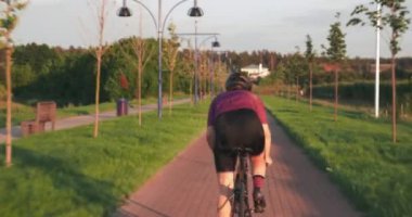 Profesyonel kadın bisikletçi bisikletle pedal çevirmek zordur. Kadın sporcu bisikletle koşuyor. Triatloncu gün batımında bisikletle ileri gidiyor. Sporcu kadın bisiklet sürme antrenmanı yapıyor. Döngü çalışması