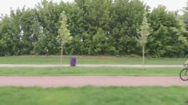 Bisikletli kadın bisikletçinin drone görüntüsü. Kasklı ve bisiklet elbiseli kadın bisiklet eğitimi alıyor, dışarıda kardiyo egzersizleri yapıyor. Bisiklet eğitimi. Kız bisiklette sıkı çalışıyor..