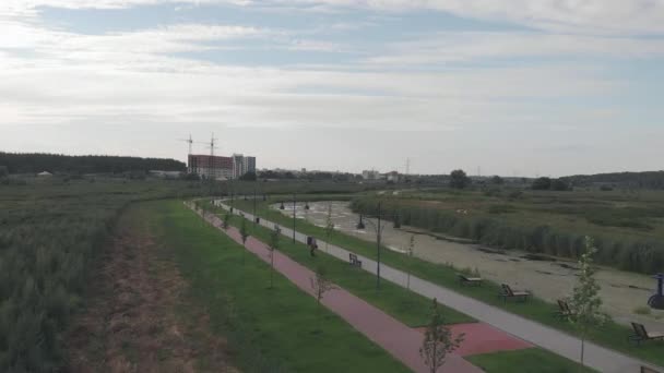 Drohnenblick auf die leere Flusspromenade mit Fuß- und Radweg. Leere Kaianlage im Hintergrund mit städtischen Gebäuden — Stockvideo