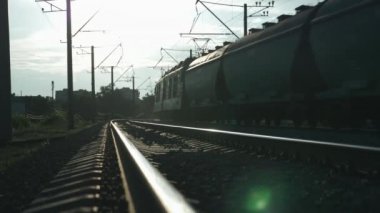 Gün batımında vagonlu tren raylara çıkar. Gün batımında trenli demiryolu. Uzun yük treni yük arabalarında mal taşır. Demiryolunda tren yolculukları. Tren gün doğumunda kırsalda geziyor.