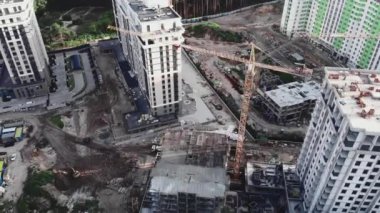 İnşaat alanının en üst manzarası vinçler ve ormandaki modern yerleşim alanlarının tamamlanmamış binaları. Vinçler inşaat alanında çalışıyor