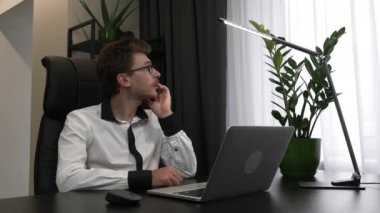 Gözlüklü adam modern iş ofisinde cep telefonuyla konuşuyor. Kafkasyalı özgüvenli işadamı iş yerinde akıllı telefonla konuşuyor. Erkek çalışan telefonda konuşuyor.