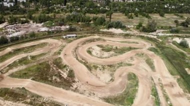 Motosikletli, ekstrem spor motosiklet pistinde motosiklet sürüyor. Motosikletli sporcu, manzaralı. Kapalı toprak devreli motokros pisti