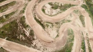 Profesyonel yarışçı tepe boyunca motosiklet sürüyor. Motosikletli, motokros dayanıklılık pistinde antrenman yapıyor.